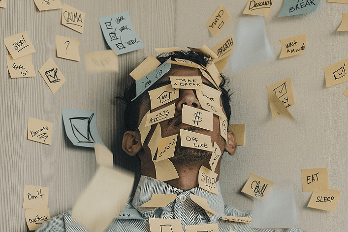 Viele beschriftete Post-It Zettel kleben im Gesicht einer Person und um sie herum © Unsplash