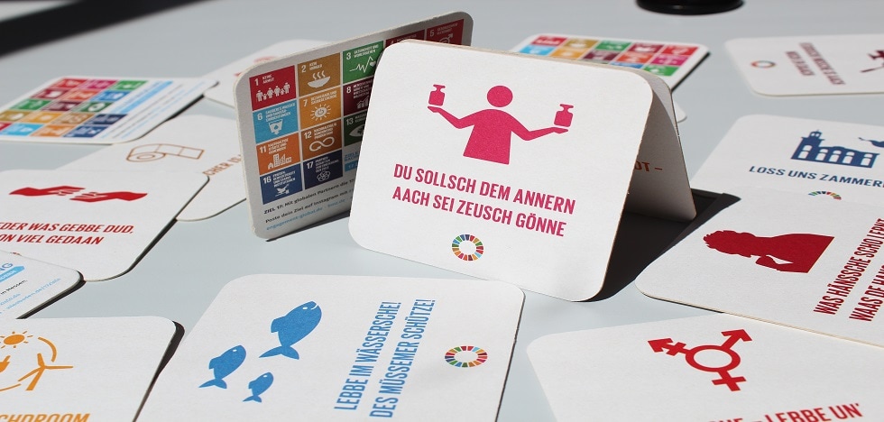 Bierdeckel mit bunten 17 Ziele Motiven und Sprüchen aus Hessen. © Engagement Global